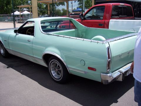 1972 Ford Ranchero - A light green 1972 Ford Ranchero is parked outdoors next to a red pickup truck.