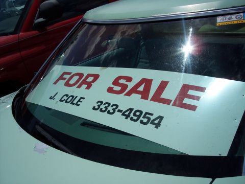1972 Ford Ranchero - A "FOR SALE" sign is displayed on the windshield of a light colored vehicle, with another red vehicle visible behind it.