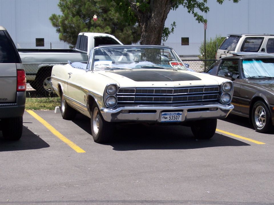 Cream convertible with black hood and quad headlights. License plate 53507