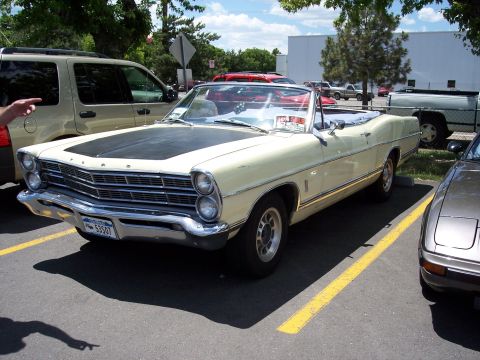 1972 Ford Ranchero - A classic convertible is parked in a lot next to an SUV and another car.
