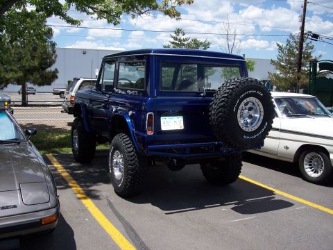 1972 Ford Ranchero - A lifted blue 1975 Ford Bronco is parked outdoors, showing its rear and spare tire.
