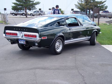 1972 Ford Ranchero - Rear view of a dark green 1968 Shelby GT500 Mustang parked outdoors.