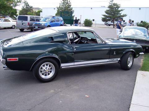 1972 Ford Ranchero - A classic dark green Ford Mustang GT350 is parked in a lot with other vehicles visible.