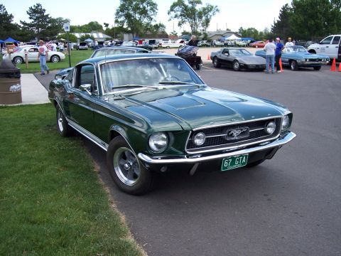 1972 Ford Ranchero - A green 1967 Ford Mustang is displayed at an outdoor car show with other vehicles present.