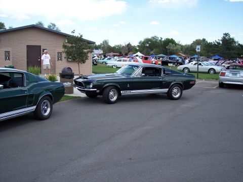 1972 Ford Ranchero - A dark green 1968 Ford Mustang fastback is parked next to another car at an outdoor event.