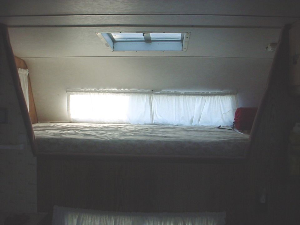 Camper bed with skylight and curtains