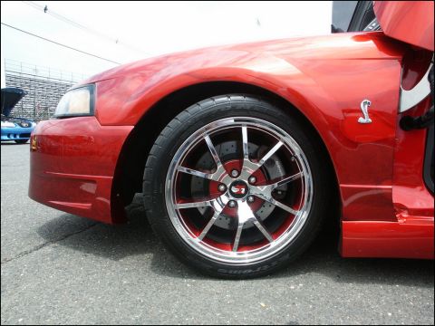 2001 Mercury Grand Marquis - A red coupe is shown from the front quarter with custom chrome and red wheels.