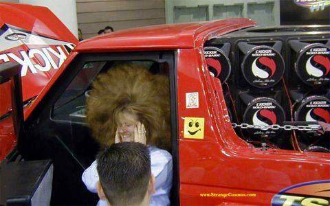 1981 Ford Bronco - A woman with voluminous hair is inside a red truck, which is equipped with several Kicker audio speakers.