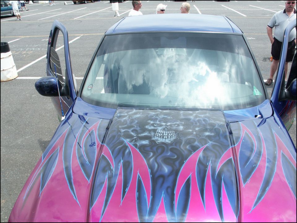 Car with flames and skull airbrushed on the hood, doors open
