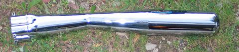1994 Ford Bronco - A chrome exhaust pipe with dual outlets rests on a grassy surface.