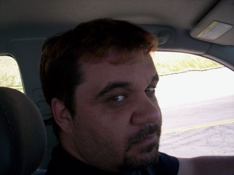 1989 Ford Bronco - A man is seen from the side inside a vehicle, looking back towards the camera.
