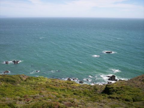 1989 Ford Bronco - A scenic view of the ocean meeting a coastline with waves breaking against rocks.