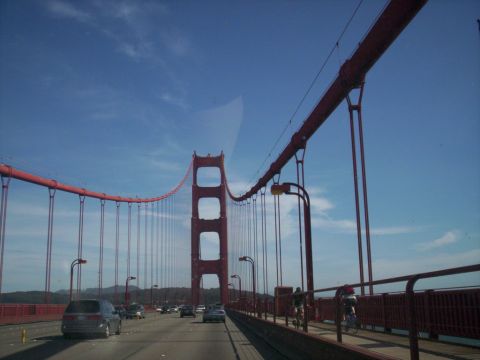 1989 Ford Bronco - Driving across the Golden Gate Bridge with traffic and cyclists visible.