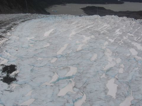1973 Ford Ranchero - A vast glacier stretches towards a lake, with dark mountains rising in the distance.