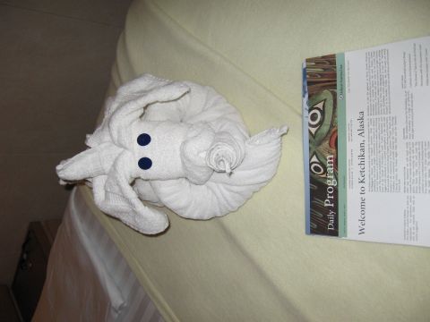 1973 Ford Ranchero - A towel animal and a daily program document are placed on a bed.