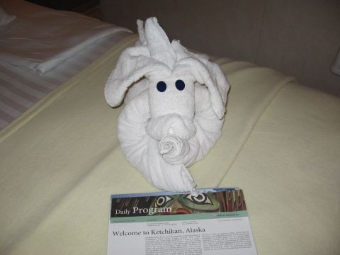 1973 Ford Ranchero - A towel folded into an animal shape sits on a bed next to a daily program welcoming visitors to Ketchikan, Alaska.