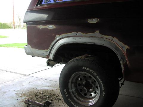1981 Ford Bronco - This Ford Bronco's rear quarter panel is undergoing bodywork, revealing areas of rust and primer.