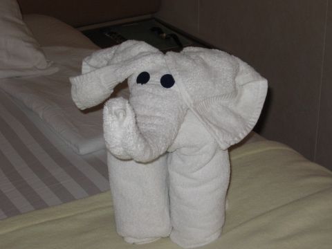 1973 Ford Ranchero - A white towel is folded into the shape of an elephant, complete with ears and a trunk, resting on a bed.