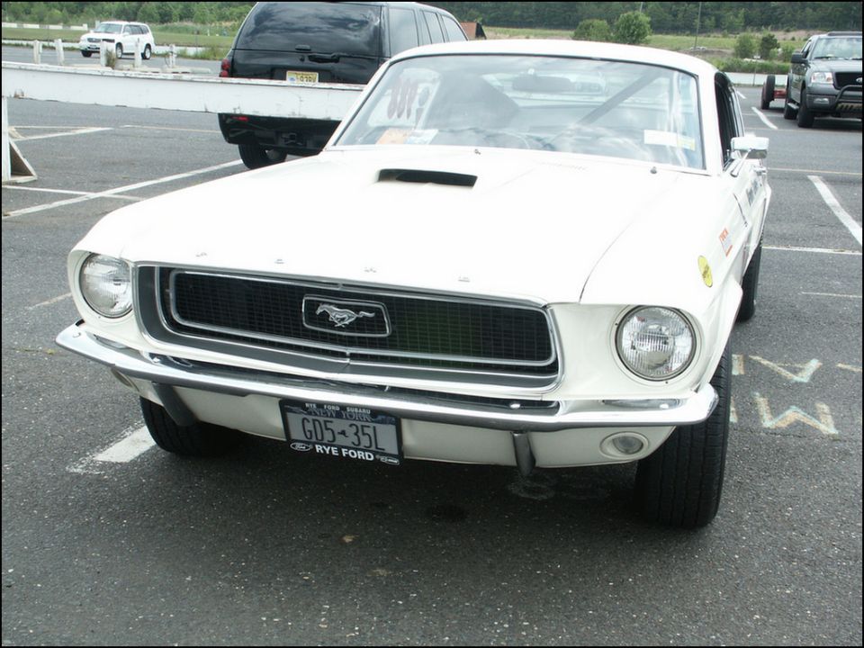 Front view of a white 1967 Ford Mustang with a black grille and a license plate reading GD5-35L