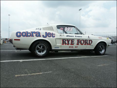 2001 Mercury Grand Marquis - A white 1967 Ford Mustang Cobra Jet race car is parked on asphalt, displaying "Cobra Jet" and "Rye Ford" graphics.