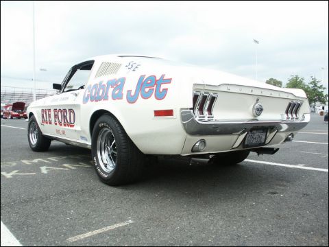 2001 Mercury Grand Marquis - A classic Ford Mustang Cobra Jet is seen from the rear, displaying custom graphics and a license plate.