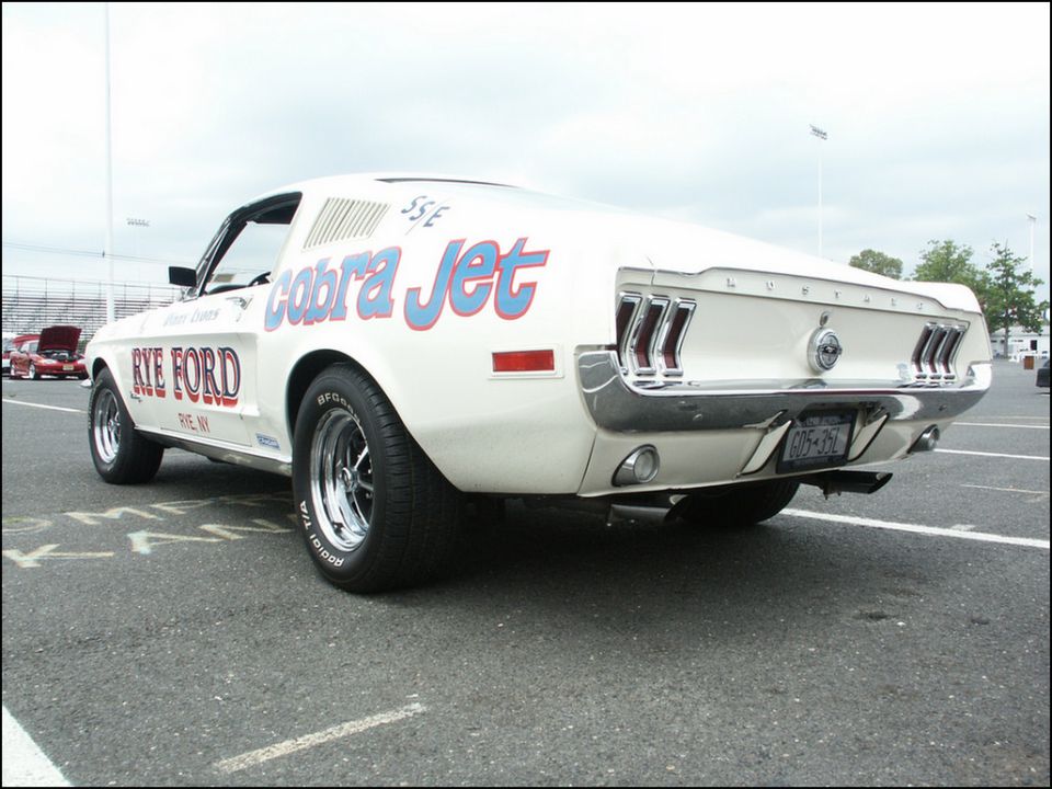 White 1967 Ford Mustang Cobra Jet with 'Rye Ford' and 'Cobra Jet' graphics, parked on asphalt