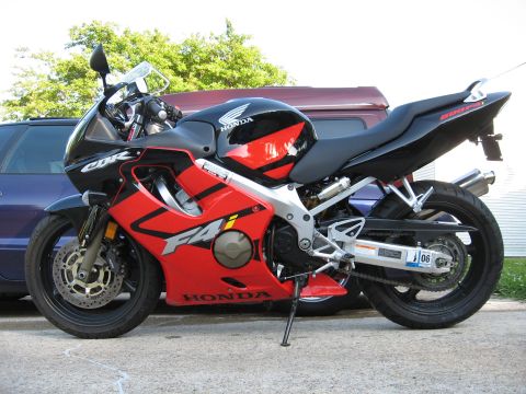 2004 Honda CBR600F - A red and black Honda CBR600F motorcycle is parked outdoors, with a car visible in the background.