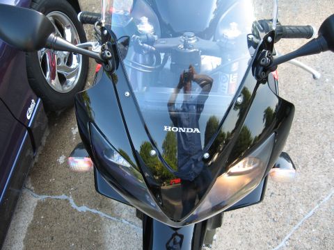 2004 Honda CBR600F - Front view of a black Honda motorcycle with its headlights on, parked beside a purple car.