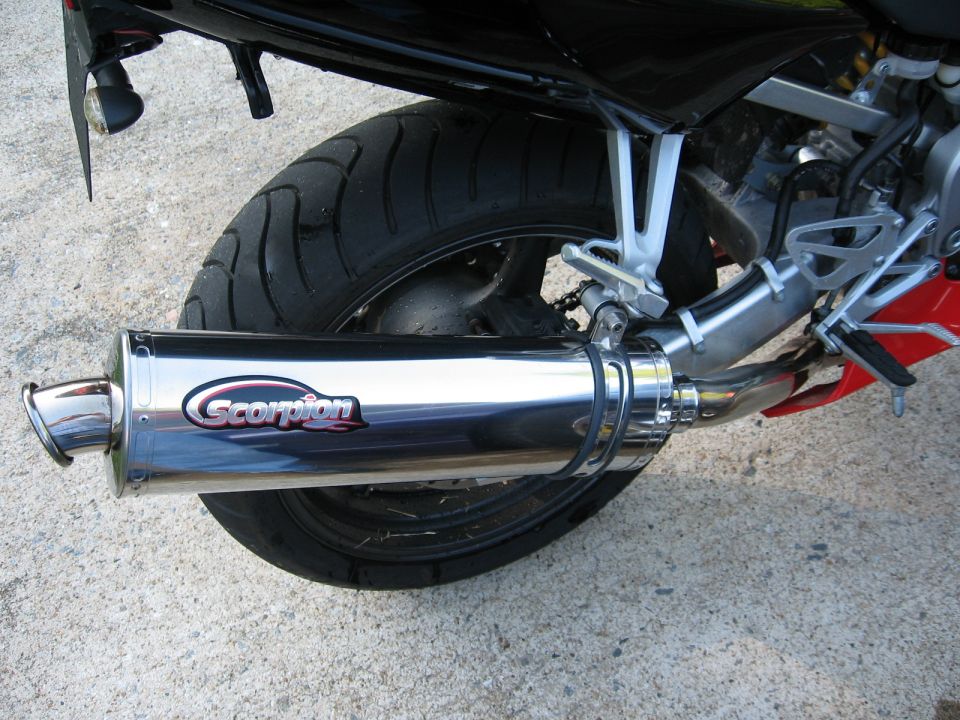 Polished Scorpion exhaust muffler mounted on a sportbike rear wheel