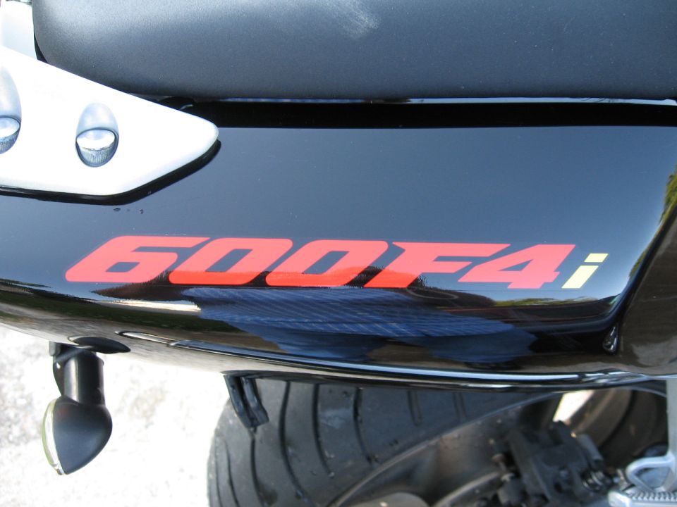 Close-up of a motorcycle's black tail section with red '600F4i' lettering