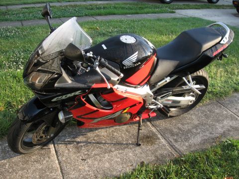 2004 Honda CBR600F - Motorcycle with Honda branding and CBR lettering on the fairing, parked outdoors.
