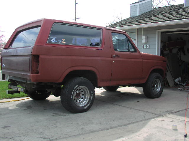 Maroon primered two-door Bronco in driveway, rear bumper removed