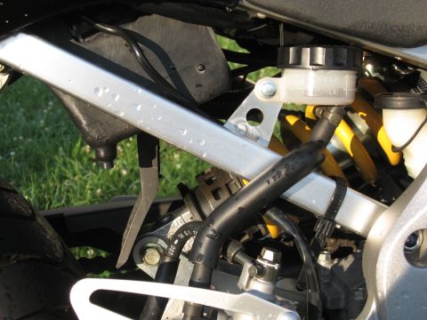2004 Honda CBR600F - Detail shot of a motorcycle's rear suspension system and brake lines.