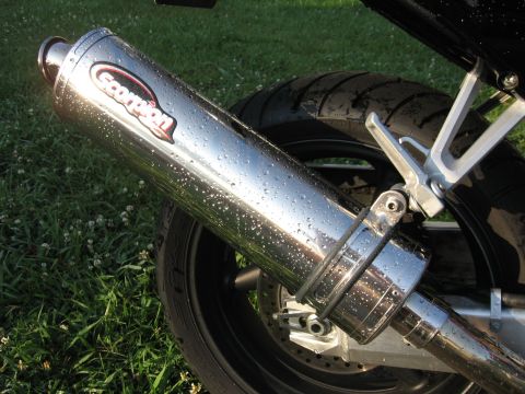 2004 Honda CBR600F - A motorcycle's chrome exhaust pipe, branded 'Scorpion', is shown up close with water droplets after rain.
