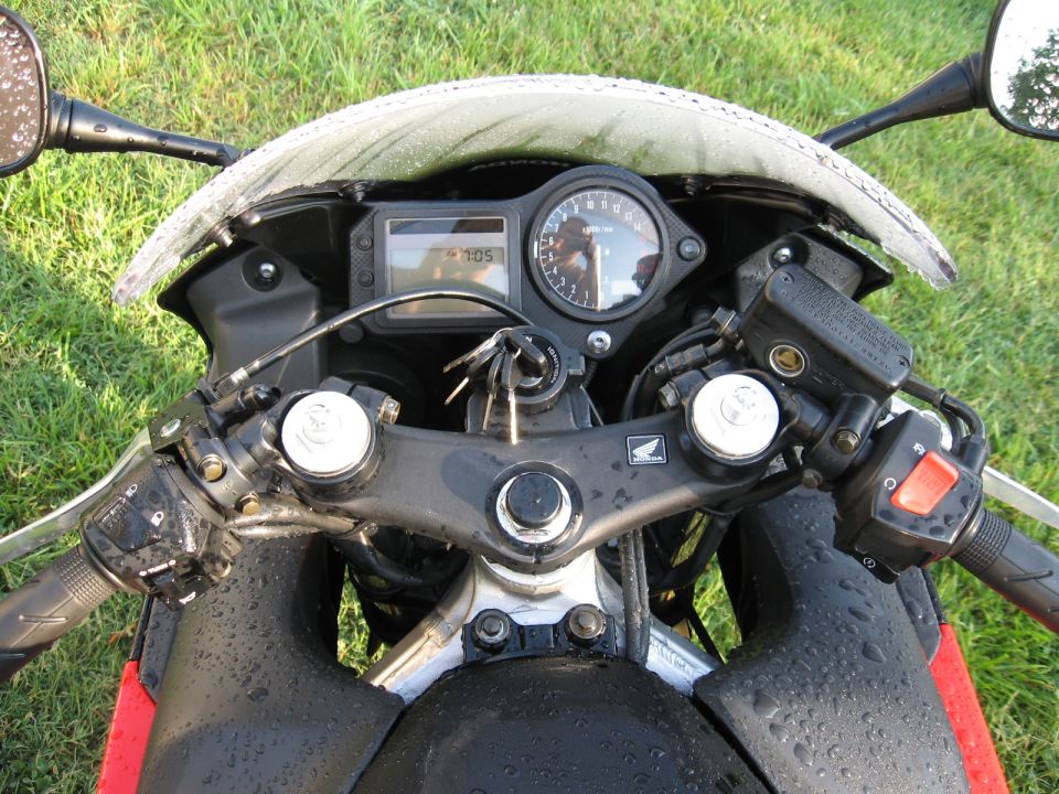 Top-down view of Honda sport bike cockpit with instrument cluster showing 705 miles