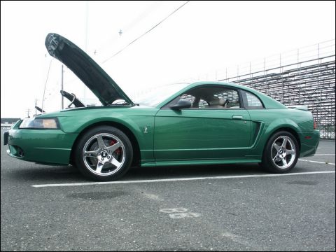 2001 Mercury Grand Marquis - A green coupe, possibly a Ford Mustang, is shown with its hood open and aftermarket wheels.
