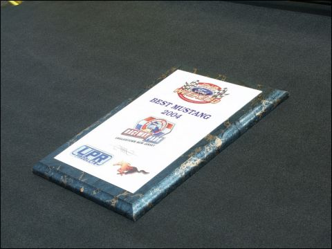 2001 Mercury Grand Marquis - Photograph of a car-show award plaque lying on carpet, not a technical document.