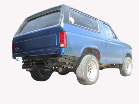 1981 Ford Bronco - This blue Ford Bronco is shown from the rear, highlighting its modified bumper and exhaust system.