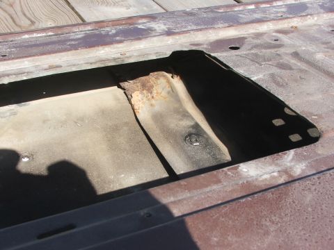 1994 Ford Bronco - Close-up of a rusted metal panel with a cutout, revealing internal structure.