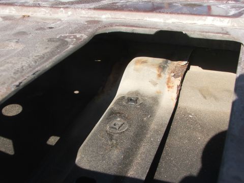 1994 Ford Bronco - This photo shows a close-up of a rusted metal bracket, likely from the interior of a vehicle.