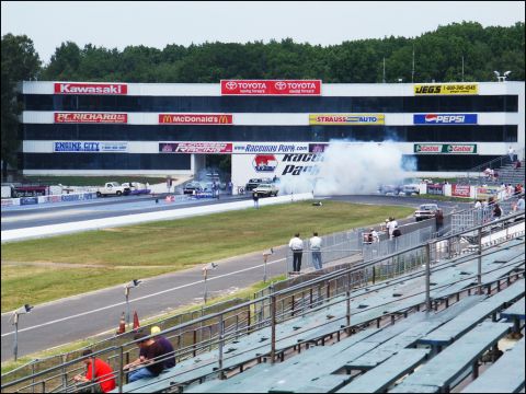 2001 Mercury Grand Marquis - Drag racing event at Raceway Park with multiple vehicles competing and spectators watching from the stands.