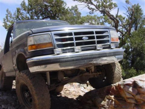 1986 Ford Bronco - This Ford Bronco is navigating a rocky trail with its front end angled upwards.