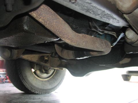 1981 Ford Bronco - Undercarriage view of a vehicle, revealing suspension parts and a tire.