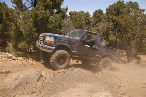 1986 Ford Bronco - This Ford Bronco appears to be from the 1992-1996 generation, not a 1986 model, as it tackles a challenging off-road path.