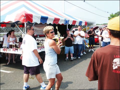 2001 Mercury Grand Marquis - People gather under a tent at an outdoor car show, with a red vehicle visible in the background.