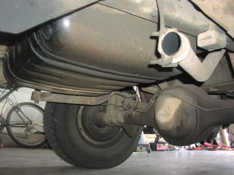 1981 Ford Bronco - A close-up view of the undercarriage reveals the rear axle, fuel tank, and exhaust system of a vehicle.