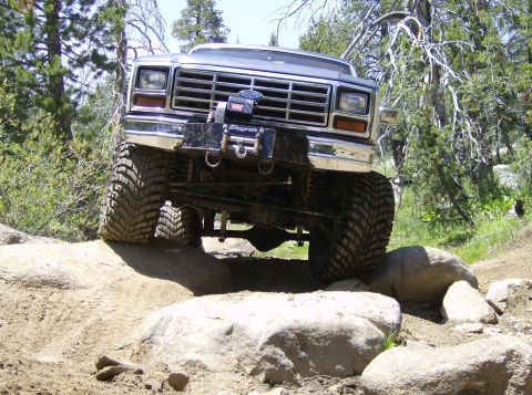 1986 Ford Bronco - This lifted Ford Bronco navigates a rocky trail with large tires.