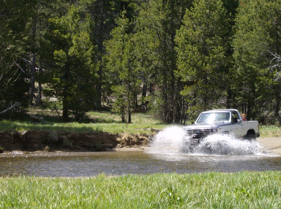 Ford F-Series truck driving through water, splashing up