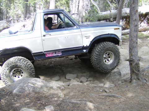 1986 Ford Bronco - This 1986 Ford Bronco navigates a rocky trail with large off-road tires.