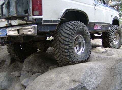 1986 Ford Bronco - This modified SUV is shown off-roading on a rocky terrain.